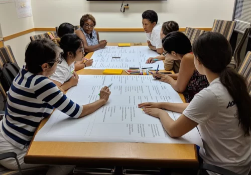 A group of people sitting at a table with papers.