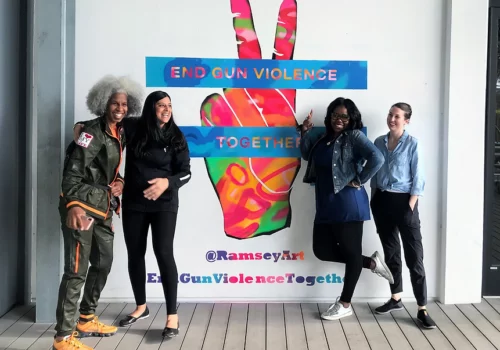 Four women standing in front of a peace sign.